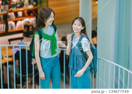 友達と大学構内の階段を上る女子大生 134677549
