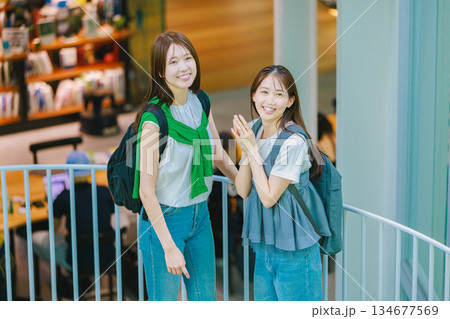 友達と大学構内の階段を上る女子大生 134677569