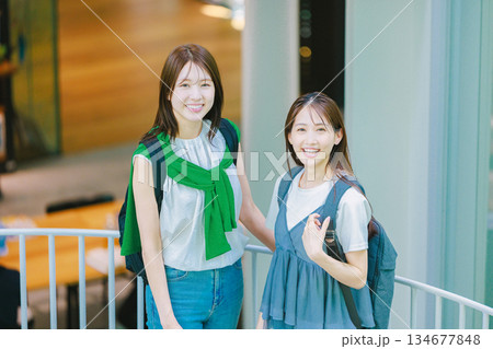 友達と大学構内の階段を上る女子大生 134677848