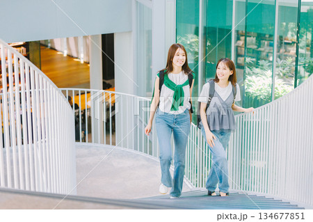 友達と大学構内の階段を上る女子大生 134677851
