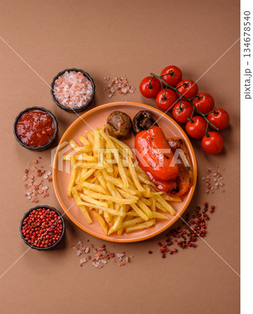 French fries cooked in oil, crispy golden chips, unhealthy food. French fries as a background French fries cooked in oil, crispy golden chips, unhealthy food. French fries as a background 134678540