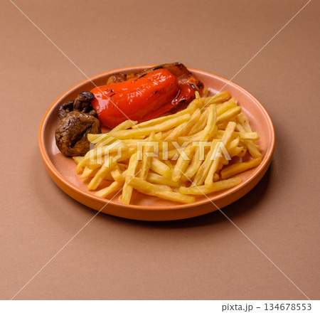 French fries cooked in oil, crispy golden chips, unhealthy food. French fries as a background French fries cooked in oil, crispy golden chips, unhealthy food. French fries as a background 134678553