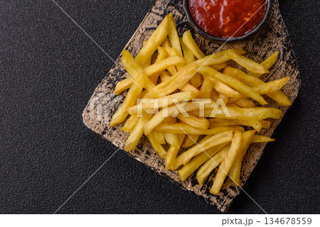 French fries cooked in oil, crispy golden chips, unhealthy food. French fries as a background French fries cooked in oil, crispy golden chips, unhealthy food. French fries as a background 134678559