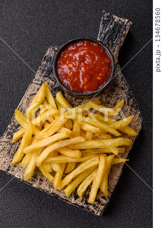 French fries cooked in oil, crispy golden chips, unhealthy food. French fries as a background 134678560