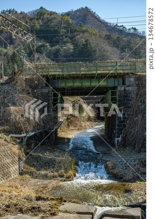 小さな鉄橋に下に流れる小川 134678572