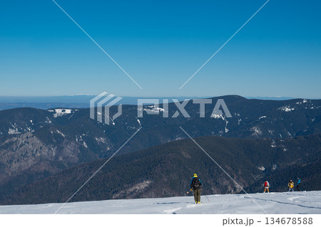 Skier standing on snowy mountain ridge overlooking vast winter landscape, wearing backpack and helmet, symbolizing adventure, freedom, backcountry skiing and alpine outdoor exploration Skier standing on snowy mountain ridge overlooking vast winter landscape, wearing backpack and helmet, symbolizing adventure, freedom, backcountry skiing and alpine outdoor exploration 134678588