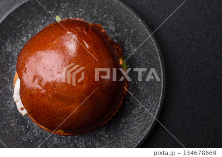 A burger, a hamburger with cheese, beef, and a bun, is unhealthy takeaway food. A burger 134678669