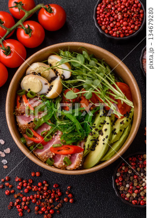 Seared tuna tataki in a bowl with sesame seeds, rice, and vegetables. Tuna tataki 134679280