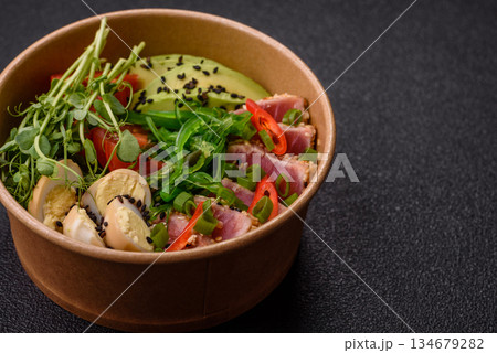 Seared tuna tataki in a bowl with sesame seeds, rice, and vegetables. Tuna tataki 134679282