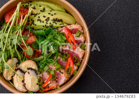 Seared tuna tataki in a bowl with sesame seeds, rice, and vegetables. Tuna tataki 134679283