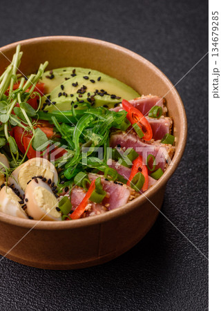 Seared tuna tataki in a bowl with sesame seeds, rice, and vegetables. Tuna tataki 134679285