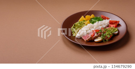 Seared tuna tataki in a bowl with sesame seeds, rice, and vegetables. Tuna tataki 134679290