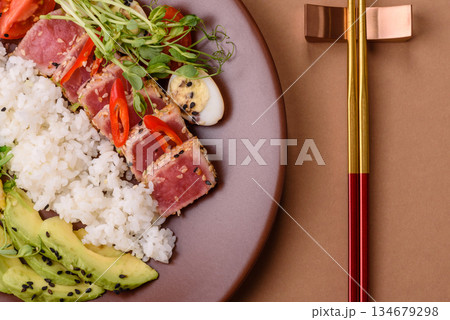 Seared tuna tataki in a bowl with sesame seeds, rice, and vegetables. Tuna tataki Seared tuna tataki in a bowl with sesame seeds, rice, and vegetables. Tuna tataki 134679298