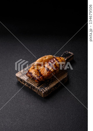 Grilled boneless chicken legs baked on the barbecue for lunch. Grilled chicken as a background Grilled boneless chicken legs baked on the barbecue for lunch. Grilled chicken as a background 134679506