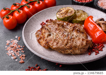 Grilled beef or pork steak, healthy restaurant food for lunch. Barbecue steak as a background Grilled beef or pork steak, healthy restaurant food for lunch. Barbecue steak as a background 134679685