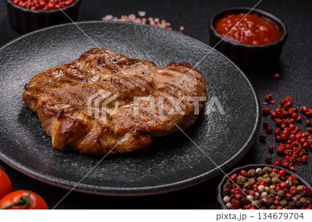 Grilled beef or pork steak, healthy restaurant food for lunch. Barbecue steak as a background Grilled beef or pork steak, healthy restaurant food for lunch. Barbecue steak as a background 134679704