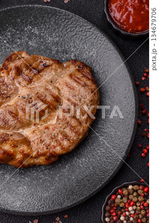 Grilled beef or pork steak, healthy restaurant food for lunch. Barbecue steak as a background Grilled beef or pork steak, healthy restaurant food for lunch. Barbecue steak as a background 134679706