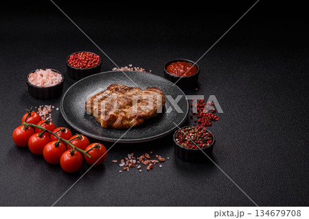 Grilled beef or pork steak, healthy restaurant food for lunch. Barbecue steak as a background Grilled beef or pork steak, healthy restaurant food for lunch. Barbecue steak as a background 134679708