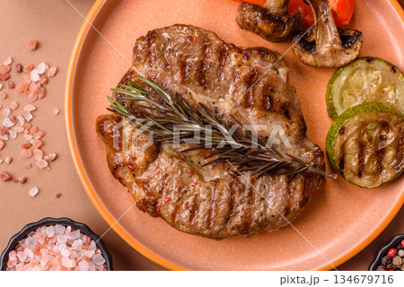 Grilled beef or pork steak, healthy restaurant food for lunch. Barbecue steak as a background Grilled beef or pork steak, healthy restaurant food for lunch. Barbecue steak as a background 134679716