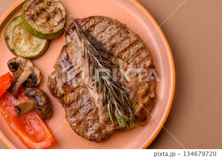 Grilled beef or pork steak, healthy restaurant food for lunch. Barbecue steak as a background Grilled beef or pork steak, healthy restaurant food for lunch. Barbecue steak as a background 134679720