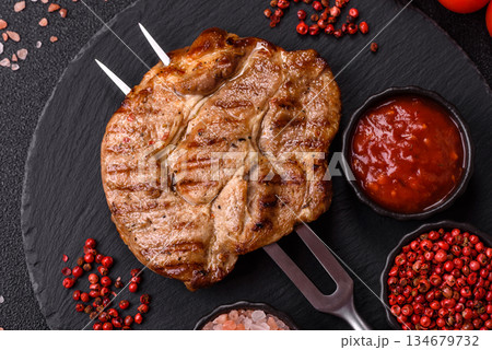 Grilled beef or pork steak, healthy restaurant food for lunch. Barbecue steak as a background Grilled beef or pork steak, healthy restaurant food for lunch. Barbecue steak as a background 134679732