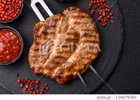 Grilled beef or pork steak, healthy restaurant food for lunch. Barbecue steak as a background Grilled beef or pork steak, healthy restaurant food for lunch. Barbecue steak as a background 134679760