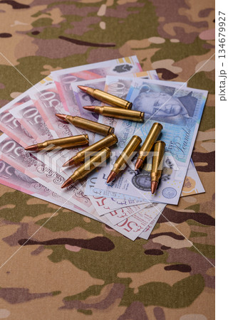 Machine gun cartridges on a camouflage background, military wallpaper. Camouflage background 134679927