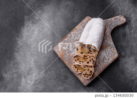 Stollen, a German Christmas pastry for the winter holidays. Stollen as a food background Stollen, a German Christmas pastry for the winter holidays. Stollen as a food background 134680030