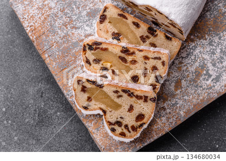 Stollen, a German Christmas pastry for the winter holidays. Stollen as a food background Stollen, a German Christmas pastry for the winter holidays. Stollen as a food background 134680034