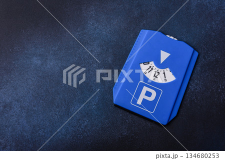 A parking disc, permit, or ticket for measuring time and paying municipal services. A parking disc A parking disc, permit, or ticket for measuring time and paying municipal services. A parking disc 134680253