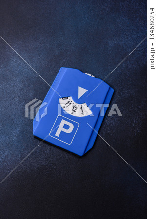 A parking disc, permit, or ticket for measuring time and paying municipal services. A parking disc A parking disc, permit, or ticket for measuring time and paying municipal services. A parking disc 134680254