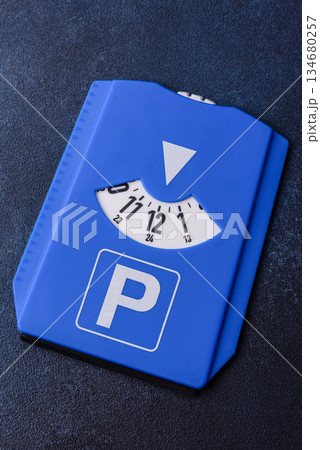 A parking disc, permit, or ticket for measuring time and paying municipal services. A parking disc A parking disc, permit, or ticket for measuring time and paying municipal services. A parking disc 134680257