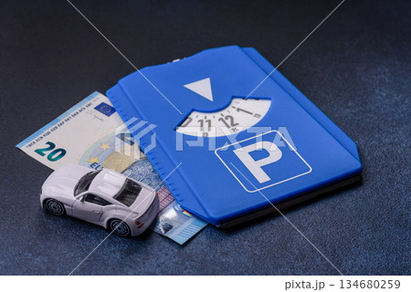 A parking disc, permit, or ticket for measuring time and paying municipal services. A parking disc A parking disc, permit, or ticket for measuring time and paying municipal services. A parking disc 134680259