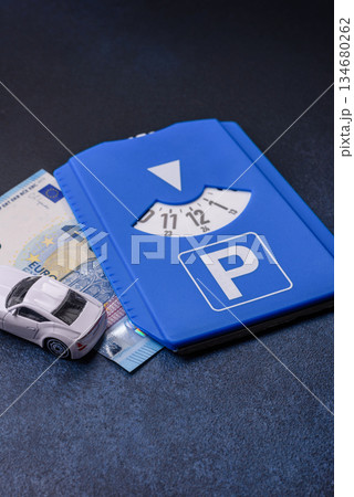 A parking disc, permit, or ticket for measuring time and paying municipal services. A parking disc A parking disc, permit, or ticket for measuring time and paying municipal services. A parking disc 134680262