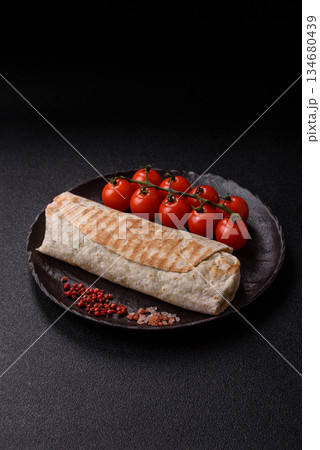 Shawarma with chicken or beef, tortilla roll, and vegetables. Shawarma with meat Shawarma with chicken or beef, tortilla roll, and vegetables. Shawarma with meat 134680439