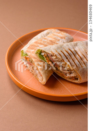 Shawarma with chicken or beef, tortilla roll, and vegetables. Shawarma with meat 134680469