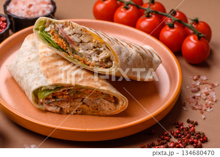 Shawarma with chicken or beef, tortilla roll, and vegetables. Shawarma with meat 134680470