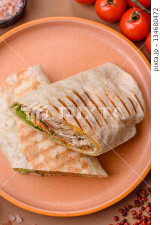 Shawarma with chicken or beef, tortilla roll, and vegetables. Shawarma with meat Shawarma with chicken or beef, tortilla roll, and vegetables. Shawarma with meat 134680472