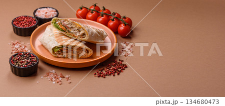 Shawarma with chicken or beef, tortilla roll, and vegetables. Shawarma with meat Shawarma with chicken or beef, tortilla roll, and vegetables. Shawarma with meat 134680473