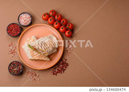 Shawarma with chicken or beef, tortilla roll, and vegetables. Shawarma with meat Shawarma with chicken or beef, tortilla roll, and vegetables. Shawarma with meat 134680474