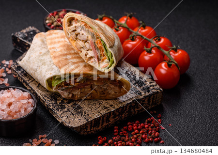 Shawarma with chicken or beef, tortilla roll, and vegetables. Shawarma with meat Shawarma with chicken or beef, tortilla roll, and vegetables. Shawarma with meat 134680484