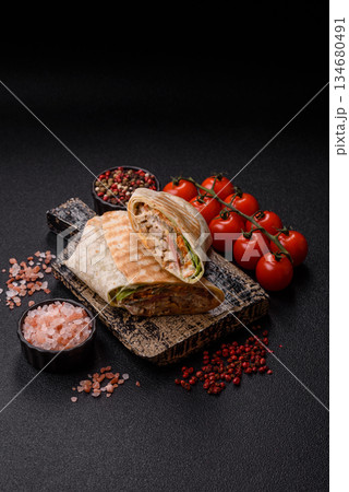 Shawarma with chicken or beef, tortilla roll, and vegetables. Shawarma with meat Shawarma with chicken or beef, tortilla roll, and vegetables. Shawarma with meat 134680491