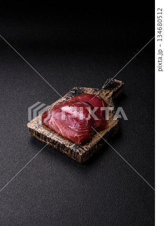 Tuna steak for sashimi or sushi, smoked fish. Tuna steak as a food background Tuna steak for sashimi or sushi, smoked fish. Tuna steak as a food background 134680512