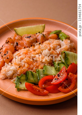 A food bowl with salmon, rice, avocado, tomatoes, and cucumbers. A salmon bowl 134681754