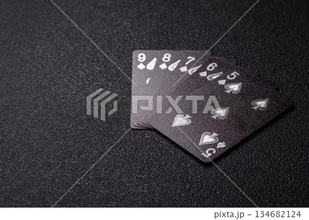 Playing card game poker in casino with chips, bets and risk. Cards and chips on black felt Playing card game poker in casino with chips, bets and risk. Cards and chips on black felt 134682124