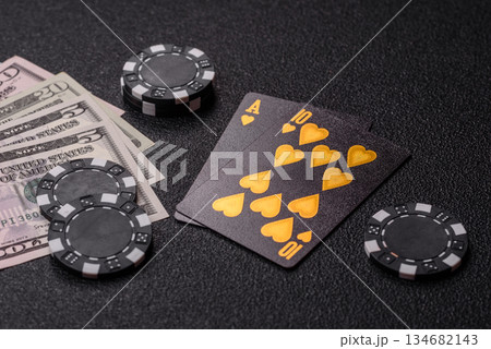 Playing blackjack or baccarat card game in casino with chips. Cards and chips on black felt Playing blackjack or baccarat card game in casino with chips. Cards and chips on black felt 134682143
