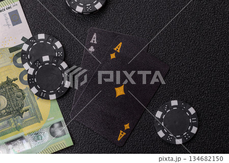 Playing blackjack or baccarat card game in casino with chips. Cards and chips on black felt 134682150