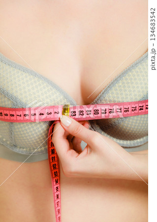Woman in bra lingerie measuring her chest breasts. Woman in bra lingerie measuring her chest breasts. 134683542