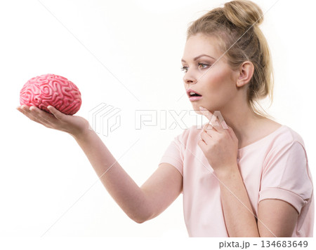 Woman holding brain having idea Woman holding brain having idea 134683649