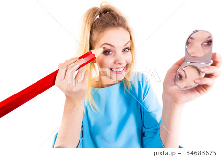 Woman painting eyebrows using regular pencil 134683675